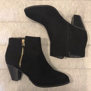 Black heeled booties with gold zipper